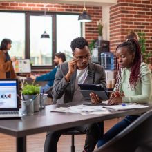 des-collegues-revisent-des-plans-sur-leur-tablette-min